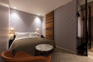 首尔Hotel Lemong的卧室配有1张床、1张桌子和1把椅子