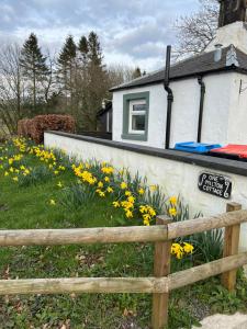 莫法特Cosy country cottage in rural location的黄色花房前的围栏