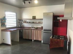 努美阿The Hideway的厨房配有红色和白色的橱柜和冰箱。