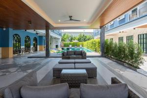 北榄Cozy Blu Suvarnabhumi的带家具的户外庭院和游泳池