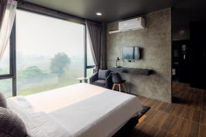 清道The View Chiang Dao Hotel的酒店客房设有一张床和一个大窗户