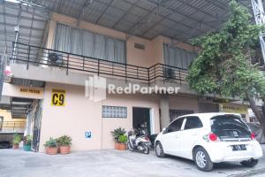 日惹Homestay C9 Exclusive Kaliurang Yogyakarta Mitra RedDoorz的停在大楼前的白色汽车