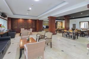 登巴萨Urbanview Hotel Taman Suci Denpasar Bali的一个带桌椅的大堂和一间餐厅