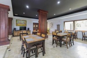 登巴萨Urbanview Hotel Taman Suci Denpasar Bali的用餐室配有木桌和椅子