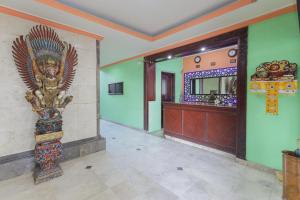 登巴萨Urbanview Hotel Taman Suci Denpasar Bali的走廊上设有雕像的建筑