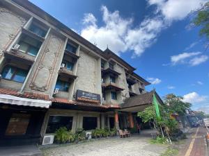 登巴萨Urbanview Hotel Taman Suci Denpasar Bali的蓝天街道上的建筑