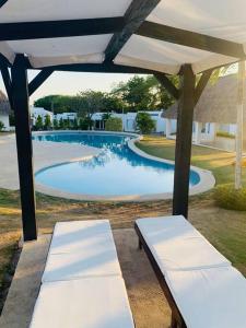 里奥阿托Enjoy a beautiful beach house in Panamá的游泳池附近两把白色长椅下