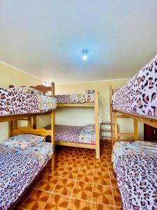皮斯科Hospedaje Anais的客房设有三张双层床,铺有瓷砖地板。