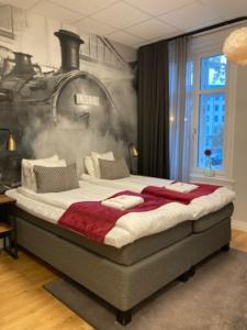 厄勒布鲁Livin Station Hotel的卧室配有一张大床,墙上挂有火车