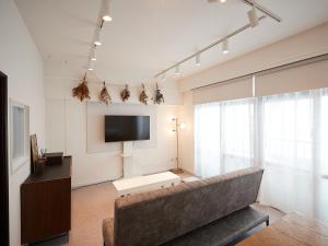 那霸Guest house II Rokumarukan的带沙发和平面电视的客厅