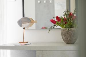 里米尼Hotel Mon Pays的一张桌子,上面有鸟形像和花瓶