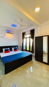 亭可马里KPN Trinco Holiday Resort的一间卧室配有一张带蓝色床单的床和一扇窗户。