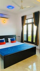 亭可马里KPN Trinco Holiday Resort的一间卧室配有一张带蓝色和橙色枕头的大床