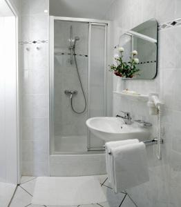 黑灵斯多夫尼普顿酒店的带淋浴和盥洗盆的白色浴室