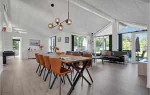 格莱斯堡Beautiful Home In Glesborg With Wifi的用餐室以及带桌椅的起居室。
