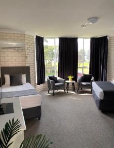North WollongongBeach Park Motel的一间卧室设有两张床、椅子和窗户。