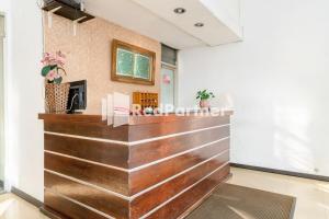 棉兰Cherry Pink Hotel Medan Mitra RedDoorz的大堂在房间内配有木台