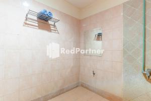 棉兰Cherry Pink Hotel Medan Mitra RedDoorz的带淋浴的浴室和玻璃门