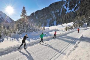 圣安东阿尔贝格"Quality Hosts Arlberg" Hotel zur Pfeffermühle的一群人沿着雪覆盖的斜坡滑雪