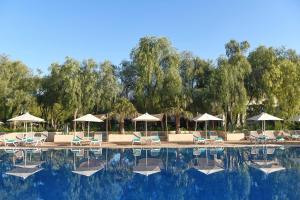 马拉喀什Iberostar Waves Club Palmeraie Marrakech All Inclusive的一个带躺椅和遮阳伞的游泳池