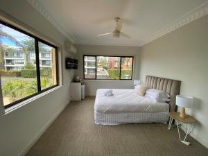 卧龙岗Normandie Wollongong的一间卧室设有一张床和两个大窗户