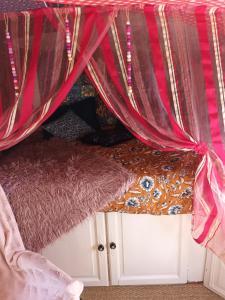 GroléjacGit'an Périgord la Bonne aventure的一张带红色窗帘和地毯的床