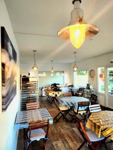 米尼赞海滩Hôtel Land'Azur的客厅配有桌椅和吊灯。
