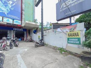 MartapuraRedDoorz Syariah near Q-Mall Banjarbaru的停在大楼前的一组摩托车