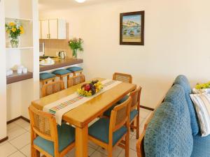 马盖特First Group Costa Smeralda的一间带木桌和椅子的用餐室
