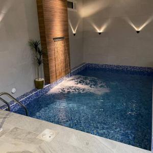 海米斯穆谢特شاليه الندى 1的浴室设有蓝色瓷砖的大型游泳池