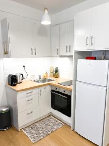 雅典Comfy 2 BDR Apt in Petralona - Next to metro的厨房配有白色橱柜和白色冰箱。