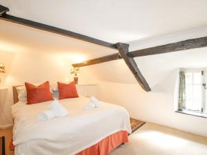 斯塔德兰Vine Cottage的卧室配有带红色枕头的大型白色床