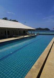 通奈潘海滩Thong Nai Pan Beach Resort的一座游泳池毗邻一座建筑和大海