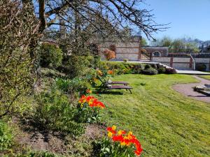 瑞米耶日克洛斯喷泉酒店的草上种着长凳和花的公园