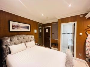 伦敦Cheshire Hotel Central London的一间带白色床的卧室和一间浴室