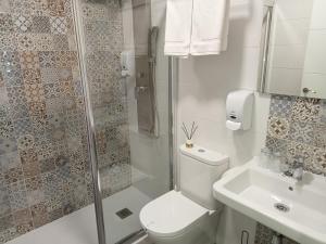 萨里亚Baixo a Lua Rooming的浴室配有卫生间、淋浴和盥洗盆。