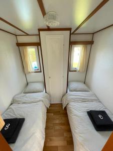 沃尔克姆Chalet D12 - Camping it Soal的带2扇窗户的小客房内的2张床
