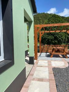 富尔纳斯Casa da Vista- Eirinha的绿色建筑,设有木制凉亭和野餐桌