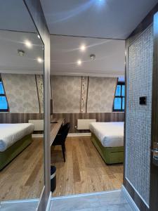 伦敦Cheshire Hotel Central London的酒店客房配有两张床和一张书桌