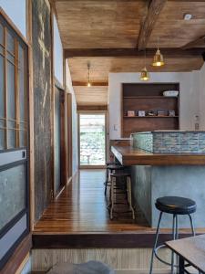 　Komori Village GH ～小森ヴィレッジ ゲストハウス～ 自然の中にある庭付平屋一棟貸的铺有木地板的厨房和带凳子的酒吧