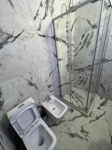 都拉斯Sunlit Coast Apartment Durrës的浴室配有卫生间、淋浴和盥洗盆。