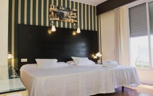 马德里HRC酒店的一间卧室配有一张大床和黑色床头板