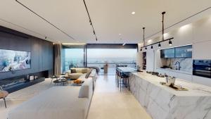 海法SERENE - Infinity Cview pool - 4 bedrooms Luxury Penthouse的厨房以及带柜台和沙发的客厅。