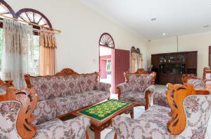 先达RedDoorz at Samuel Homestay Pematangsiantar的客厅配有沙发、椅子和桌子