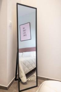 帕拉代西翁Casa d'oro 56 Living in Paradisi的卧室前的镜子,卧室配有一张床