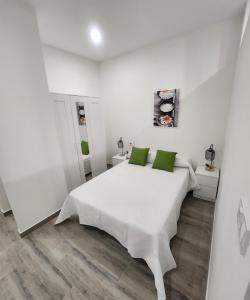 卡塔赫纳Green Apartamentos Cartagena的白色卧室配有白色床和绿色枕头