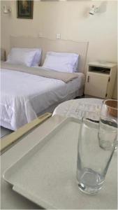 布拉瓦约Neat standard room in guesthouse - 2088的一张桌子,桌子上放着玻璃,还有两张床