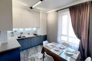 TürkistanАпартамент keruen saray的厨房配有蓝色橱柜和桌椅