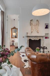 莱昂紫狗套房公寓的客厅设有真皮沙发和壁炉