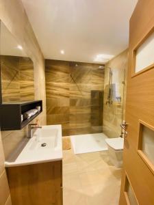 圣保罗湾城Large Seafront Maisonette的一间带水槽、淋浴和卫生间的浴室